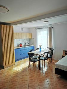 a kitchen and dining room with a table and chairs at 4 Pory Roku Apartamenty Domki Pokoje in Nadole