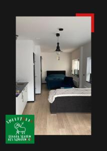 1 dormitorio con 2 camas y cocina con sofá azul en Sheepyhead en Dordrecht