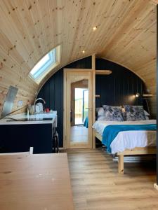 1 dormitorio con 1 cama y lavamanos en una habitación en Thistle Pod at Ayrshire Rural Retreats Farm Stay Hottub Sleeps 2 en Galston