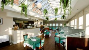 un restaurant avec des tables vertes, des chaises et des fenêtres dans l'établissement The Maypole at Wellow, à Ollerton
