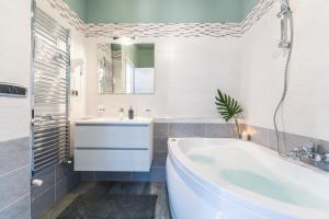 uma casa de banho branca com uma banheira e um lavatório em 4 Star Bologna Train Station - Self Check-In em Bolonha