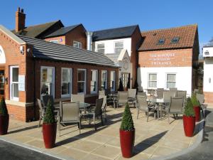 a patio with chairs and tables in front of a building at The Maypole at Wellow in Ollerton