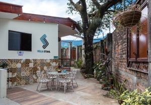 a patio with a table and chairs and a tree at Villa Stahl in San Salvador