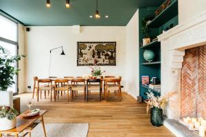 een woonkamer met een eettafel en een open haard bij Chambre d'Amis by Alix in Gent