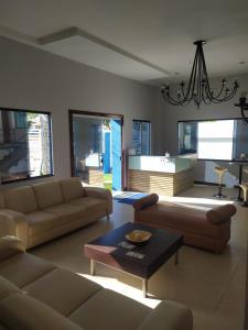 una sala de estar con sofás y una lámpara de araña. en Beautiful flat Ponta Negra sem custos adicionais!, en Natal
