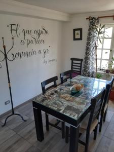 a dining room with a table and a sign on the wall at Rocio in Ushuaia
