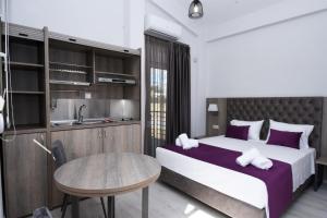 a bedroom with a bed and a table and a sink at GERANI apartments in Órmos