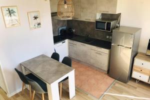 een kleine keuken met een tafel en een koelkast bij Résidence Port Soleil Duplex T3 46 m2 climatisé in Gruissan