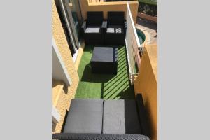 een balkon met een bank en gras bij Résidence Port Soleil Duplex T3 46 m2 climatisé in Gruissan