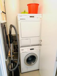 a washing machine with a bucket on top of it at Even Aan Zee - Largo in Nieuwpoort