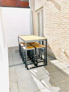 a table sitting on a sidewalk next to a building at Even Aan Zee - Largo in Nieuwpoort
