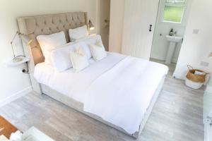 a white bed with white pillows in a bedroom at The Nook in West Mersea