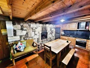 a kitchen with a table and a stone wall at Cardenha da Bessada in Branda de Santo António
