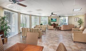 a waiting room with chairs and tables and windows at WorldMark Palm Springs in Palm Springs