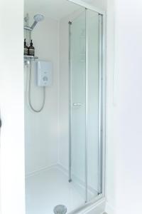 La salle de bains est pourvue d'une douche avec une porte en verre. dans l'établissement The Nook, à West Mersea