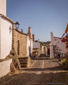 an alley with white buildings and a cobblestone street at Casa D’ Santiago in Monsaraz