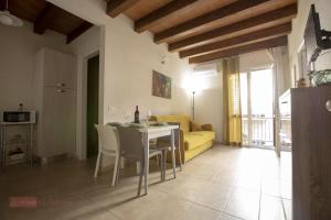 a living room with a table and a yellow couch at Le Gemme in Castellammare del Golfo