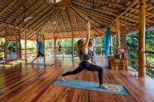 Eine Frau in einem Yoga-Kurs in einem Pavillon. in der Unterkunft Selva Armonia Immersive Jungle Resort in Uvita