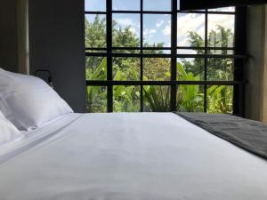 a bed in a room with a large window at Manila Hotel Boutique in Medellín