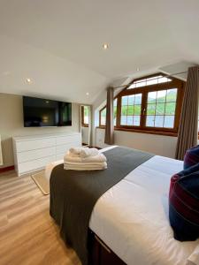 a bedroom with a large bed and a tv at 3 Sheraton Apartments in Fort William