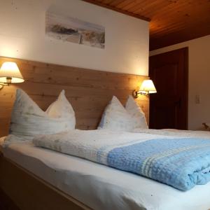 a bedroom with a bed with white pillows at Ferienhaus Hintersee in Hintersee