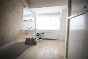 ein Badezimmer mit Badewanne und Waschbecken und einem Fenster in der Unterkunft Seaview on the beach in Port Erin + 26 Fotos