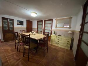 a dining room with a table and chairs and a dresser at La Cueva deLola in Alcalá del Júcar