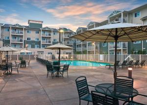 a patio with tables and chairs with umbrellas and a pool at WorldMark Long Beach in Long Beach