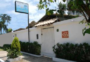 a white building with a sign in front of it at Hotel Pousada do Comendador in Guarujá