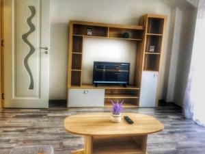 a coffee table in a room with a television and a door at Apartament cu 2 camere, spatios si confortabil. in Timişoara