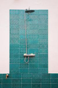 a bathroom with a blue tiled wall with a shower at Ático Terraza Torre Tavira in Cádiz