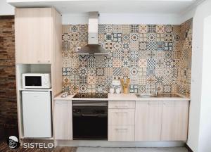 a kitchen with a sink and a tile wall at Casa do Ferreiro in Sistelo +4 photos