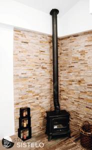um fogão preto em frente a uma parede de tijolos em Casa do Ferreiro em Sistelo