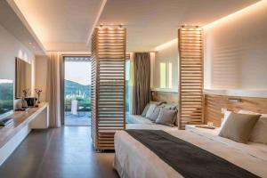 a hotel room with a bed and a balcony at Domotel Agios Nikolaos Suites Resort in Sivota