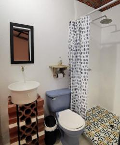 bagno con servizi igienici blu e lavandino di Hostal Colonial de Santander a Girón