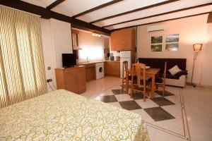 a bedroom with a bed and a table and a kitchen at Apartahotel Al Alba in Pozo Alcón