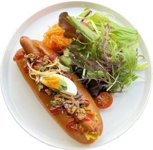 une assiette blanche avec un hot-dog et une salade dans l'établissement Hotel Cordia Osaka, à Osaka