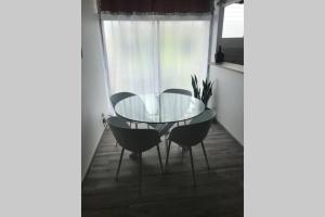 une salle à manger avec une table en verre et deux chaises dans l'établissement Bel Appartement lumineux, à Sainte-Luce