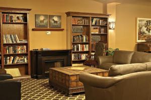 - un salon avec un canapé, une cheminée et des étagères dans l'établissement Grant Hall Hotel, à Moose Jaw