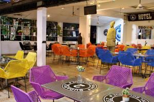 a restaurant with purple and yellow chairs and tables at Hotel Boutique Budapez in Honda