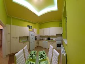 a kitchen with a table and white cabinets and a skylight at Klauzál Apartment in Szeged