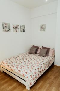 a bed in a white room with photographs on the wall at Apartament 4 Żagle in Giżycko