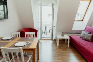 a living room with a table and a red couch at Apartament 4 Żagle in Giżycko