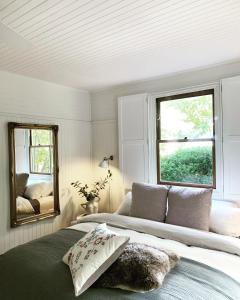 a bedroom with a large bed and a mirror at La Perouse Lorne in Lorne