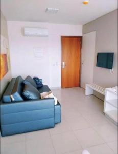 a living room with a blue couch and a television at Evian Thermas Residence - Caldas Novas in Caldas Novas