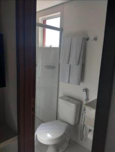 a bathroom with a toilet and a shower with towels at Evian Thermas Residence - Caldas Novas in Caldas Novas