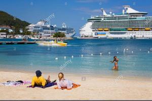 a group of people on the beach with cruise ships at Beach-side condos at Turtle Beach Towers in Ocho Rios