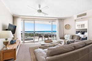 uma sala de estar com um sofá e vista para o oceano em The Duporth Riverside em Maroochydore