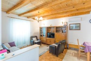 sala de estar con techos de madera, mesa y sillas en House Pansy, en Pašman