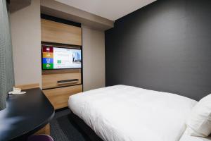 a hotel room with a bed and a flat screen tv at Hakata Nakasu Washington Hotel Plaza in Fukuoka